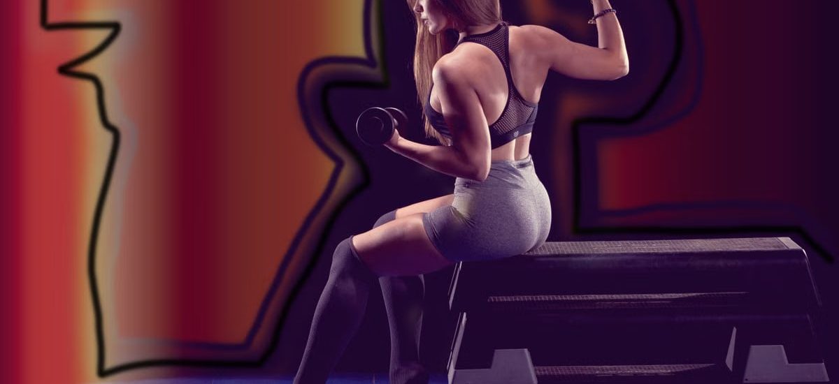 Fit woman lifting weights, showcasing strength in a gym environment.
